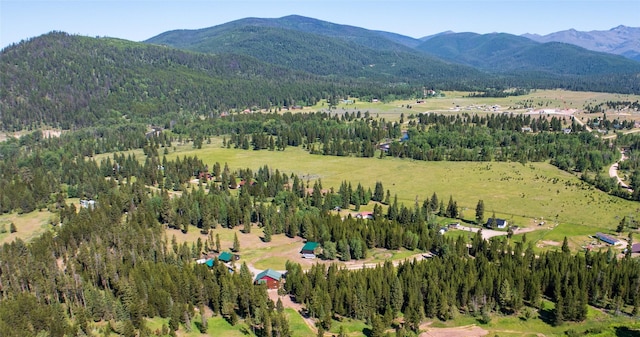 aerial view featuring a wooded view and a mountain view