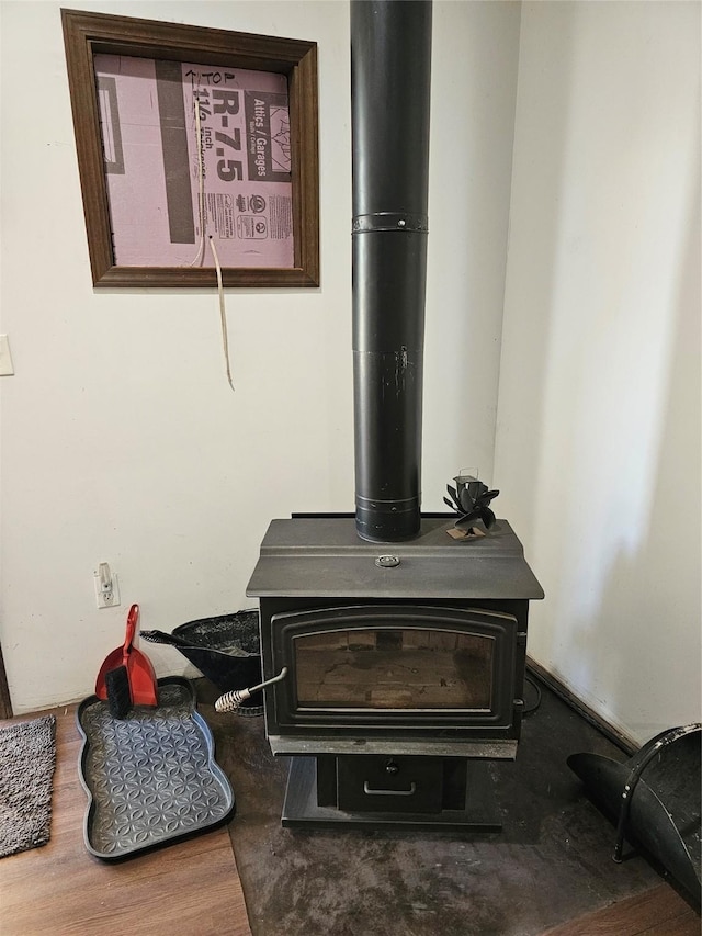 interior details with wood finished floors and a wood stove