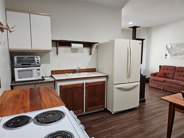 kitchen featuring a sink, a toaster, dark wood finished floors, white appliances, and wooden counters