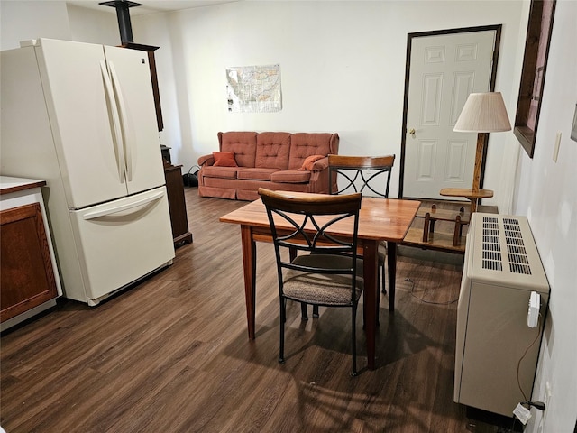 dining area with dark wood-type flooring and heating unit