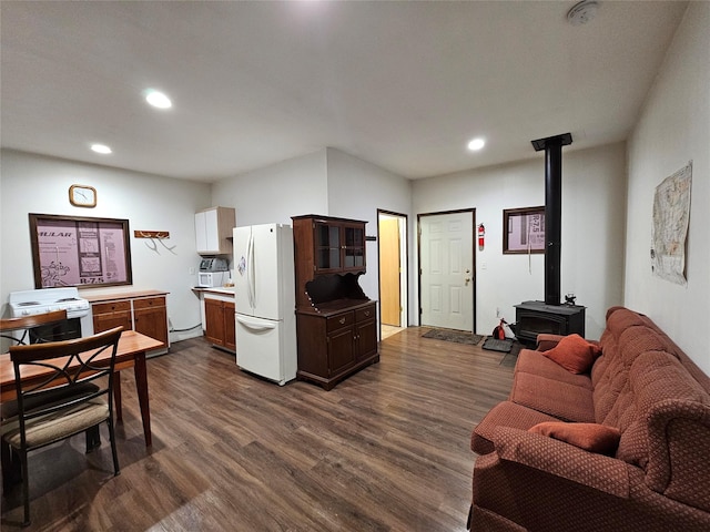 living area featuring dark wood-style floors, recessed lighting, and a wood stove