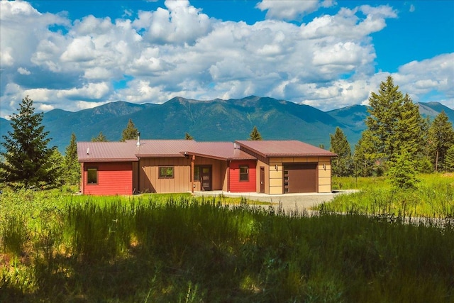 563 Riding High Dr, Eureka, MT 59917 - view of front of home featuring a mountain view, an attached garage, board and batten siding, and metal roof