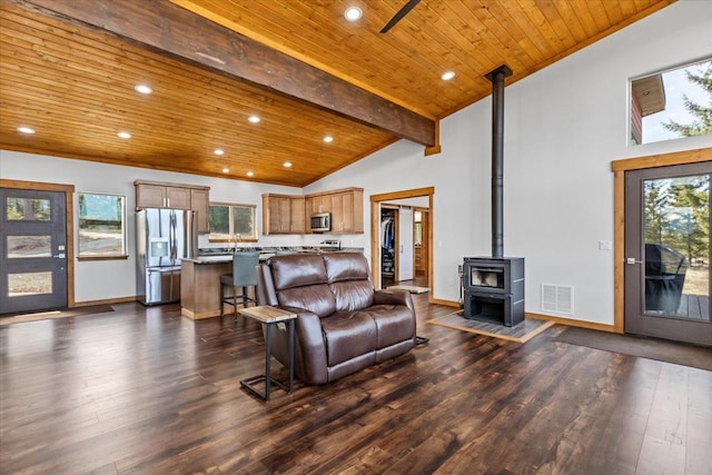 563 Riding High Dr, Eureka, MT 59917 - living room featuring a wood stove, dark wood-type flooring, plenty of natural light, wooden ceiling, and baseboards
