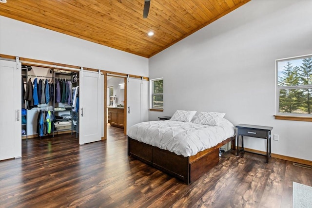 563 Riding High Dr, Eureka, MT 59917 - bedroom featuring a barn door, wooden ceiling, multiple windows, wood finished floors, and baseboards