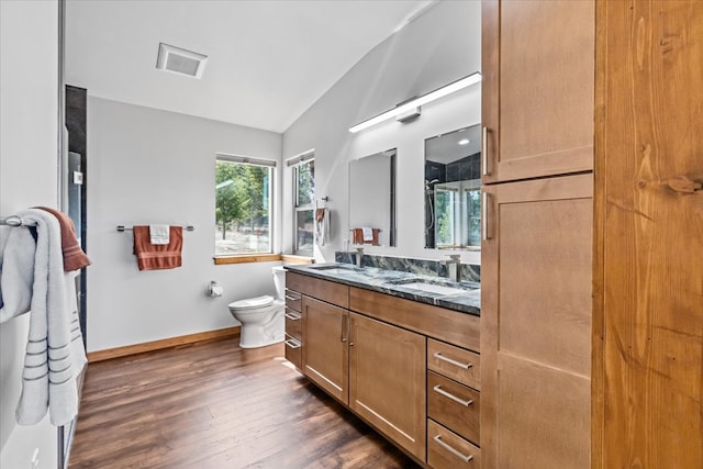 563 Riding High Dr, Eureka, MT 59917 - full bathroom with double vanity, wood finished floors, toilet, lofted ceiling, and baseboards