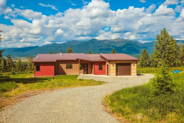 563 Riding High Dr, Eureka, MT 59917 - ranch-style home with a garage, a mountain view, driveway, and board and batten siding
