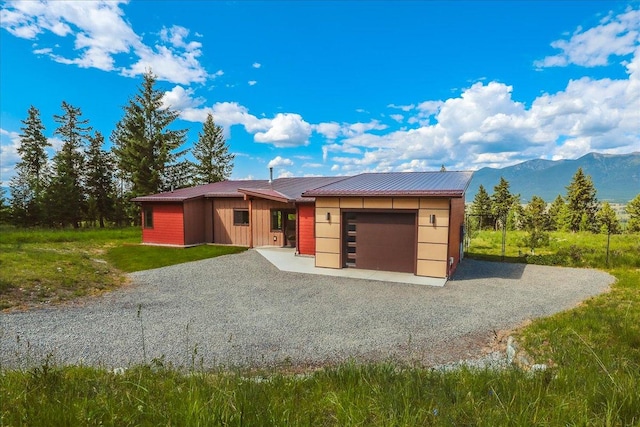 563 Riding High Dr, Eureka, MT 59917 - view of front facade featuring a garage, driveway, metal roof, and a mountain view