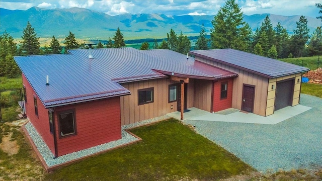 563 Riding High Dr, Eureka, MT 59917 - back of property featuring a mountain view, board and batten siding, metal roof, and a lawn