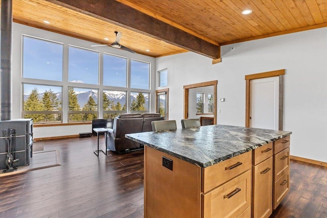 563 Riding High Dr, Eureka, MT 59917 - kitchen with wood ceiling with exposed beams, baseboards, dark stone countertops, dark wood-style flooring, and a kitchen island