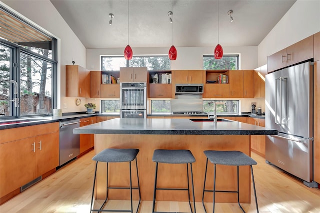 kitchen featuring light wood finished floors, visible vents, dark countertops, and stainless steel appliances