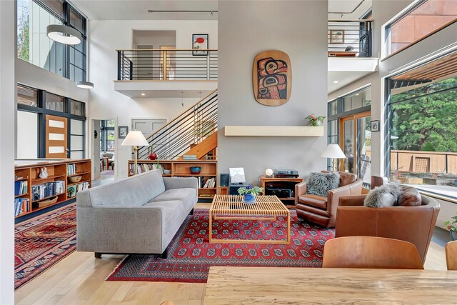 living area with wood finished floors, a high ceiling, and stairway