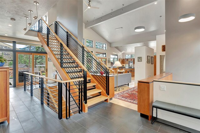 stairway featuring high vaulted ceiling, beamed ceiling, a ceiling fan, and tile patterned flooring