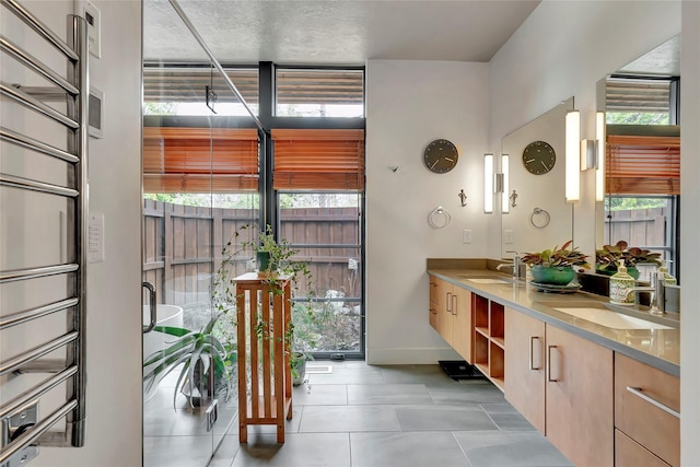 full bath featuring tile patterned floors, double vanity, a sink, and floor to ceiling windows