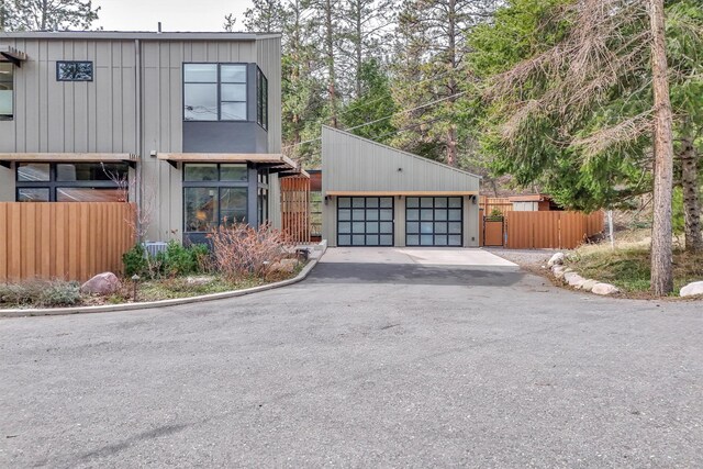 view of front of house with a garage, fence, and an outdoor structure