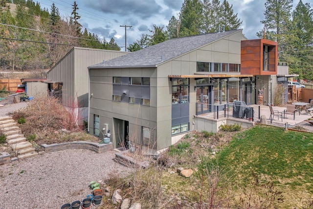 back of house with a patio and a shingled roof