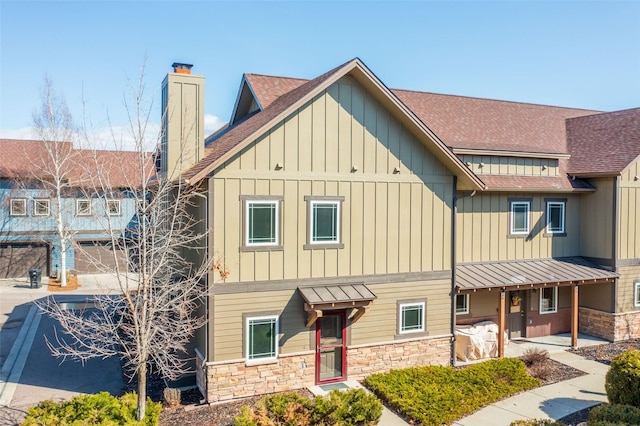 402 Sperry Ct, Whitefish, MT 59937 - view of front of home featuring stone siding, roof with shingles, board and batten siding, and a chimney