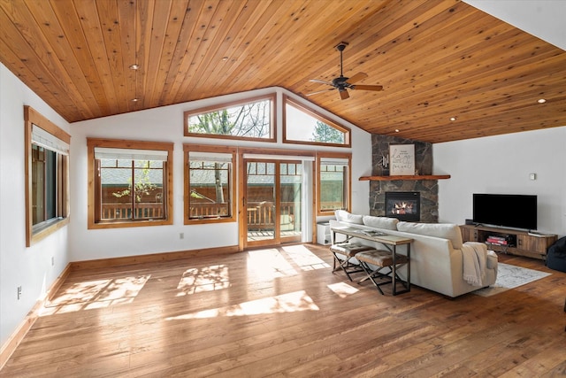 living room with wood-type flooring, ceiling fan, vaulted ceiling, and a fireplace