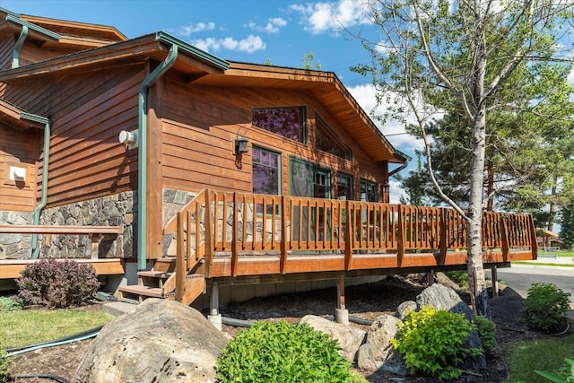 exterior space with a wooden deck and stone siding