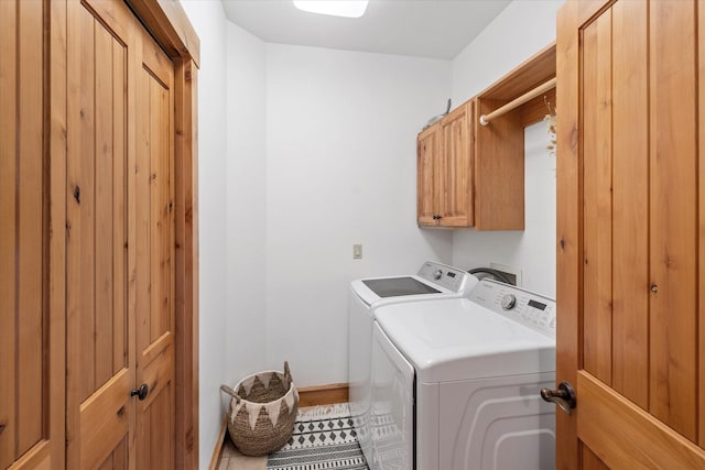 laundry area featuring baseboards, cabinet space, and washing machine and dryer