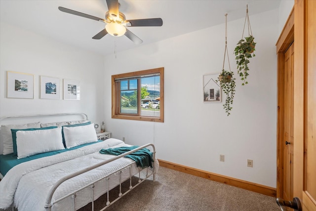 carpeted bedroom with baseboards and a ceiling fan