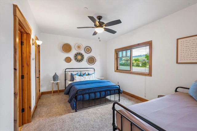 bedroom with a ceiling fan, baseboards, and light colored carpet