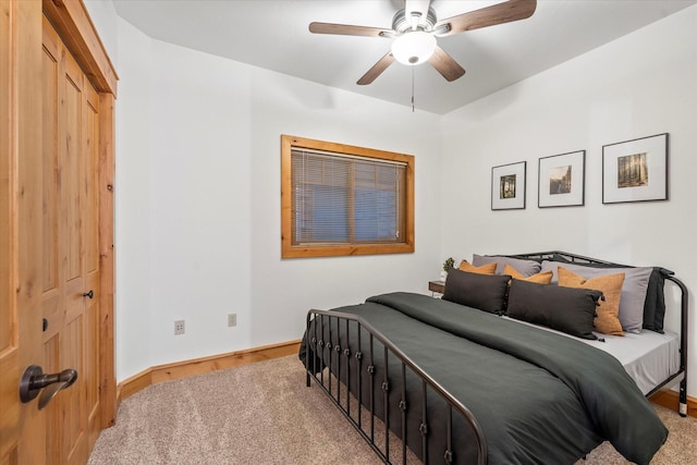 bedroom with a ceiling fan, baseboards, and light carpet