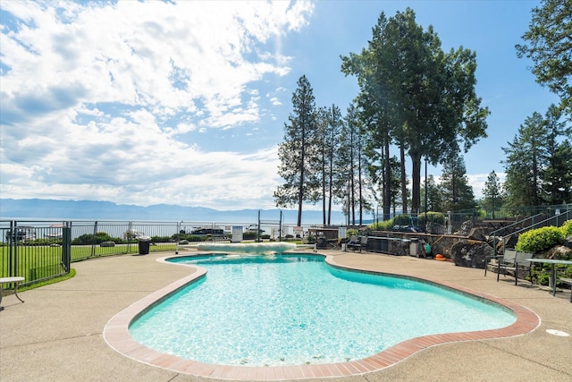 view of swimming pool featuring a fenced in pool, a patio area, fence, and a mountain view