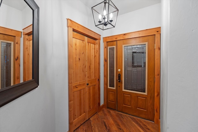 foyer entrance featuring an inviting chandelier and dark wood finished floors