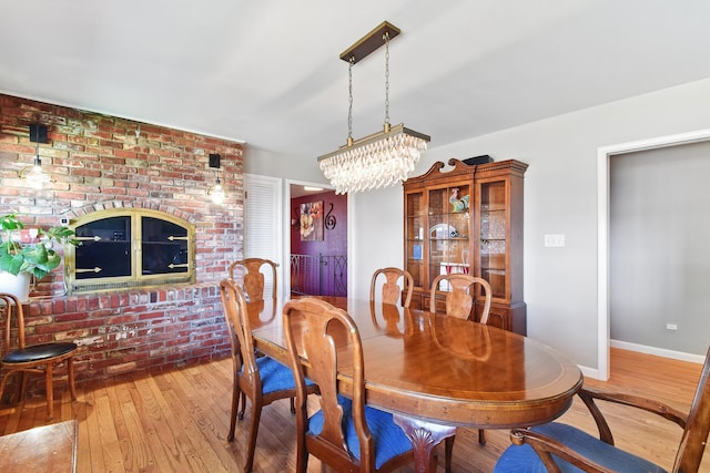 dining room featuring baseboards, a chandelier, and wood-type flooring
