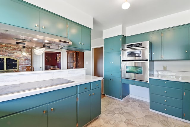 kitchen with under cabinet range hood, light countertops, black electric stovetop, and double oven
