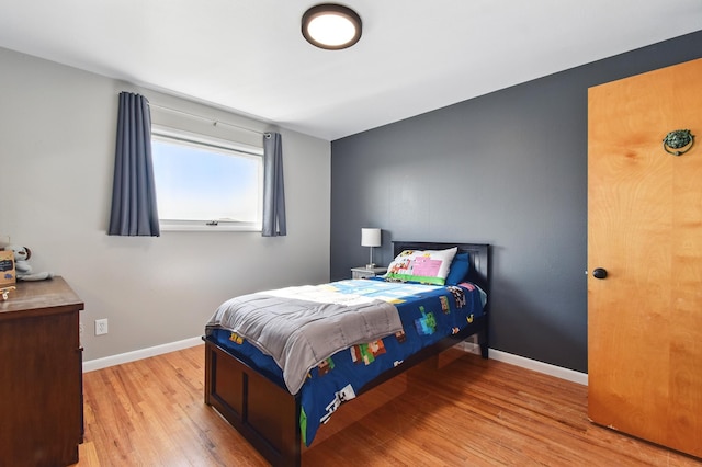 bedroom featuring baseboards and wood finished floors