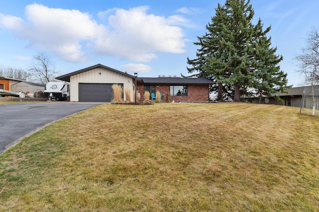 ranch-style home featuring aphalt driveway, an attached garage, a front lawn, and brick siding