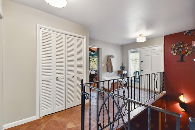 hallway with baseboards, an upstairs landing, and a wealth of natural light
