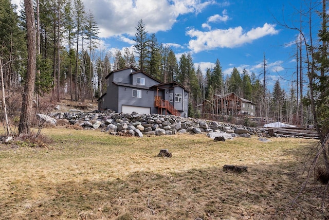 682 Latigo Ln, Bigfork, MT 59911 - view of grassy yard with an attached garage and stairway