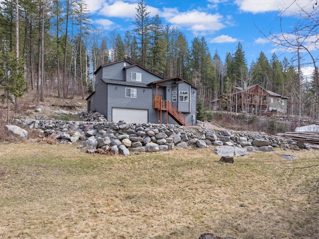 682 Latigo Ln, Bigfork, MT 59911 - view of front of home with an attached garage, a front lawn, and stairway