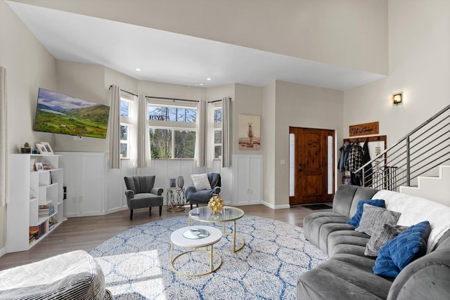 living room featuring recessed lighting, wood finished floors, and stairway