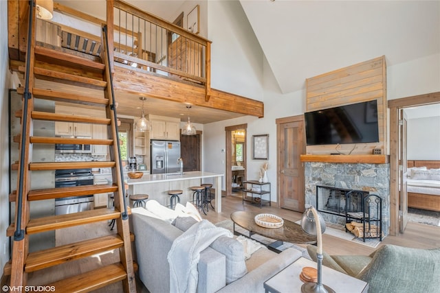 15 Haflinger Cottage Way, Eureka, MT 59917 - living room featuring wood finished floors, high vaulted ceiling, and a stone fireplace