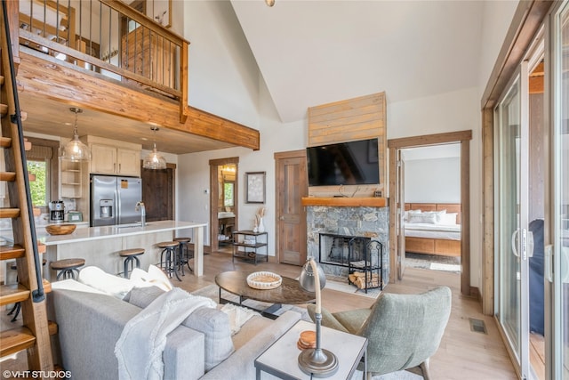 15 Haflinger Cottage Way, Eureka, MT 59917 - living area featuring high vaulted ceiling, light wood-style flooring, a fireplace, and baseboards