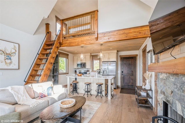 15 Haflinger Cottage Way, Eureka, MT 59917 - living area featuring stairway, high vaulted ceiling, light wood finished floors, and a fireplace