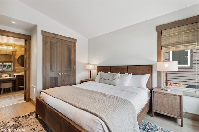 15 Haflinger Cottage Way, Eureka, MT 59917 - bedroom with vaulted ceiling, light wood-style floors, a closet, and ensuite bathroom