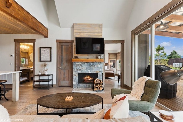 15 Haflinger Cottage Way, Eureka, MT 59917 - living room with vaulted ceiling, light wood finished floors, a stone fireplace, and baseboards