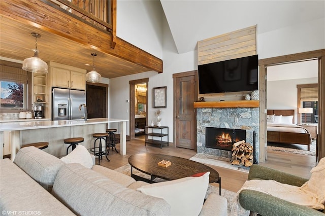 15 Haflinger Cottage Way, Eureka, MT 59917 - living area with a stone fireplace, light wood finished floors, and high vaulted ceiling