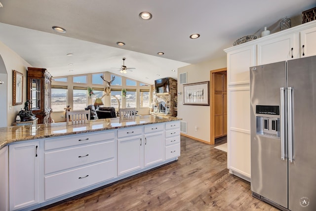 kitchen featuring light wood-type flooring, vaulted ceiling, white cabinets, ceiling fan, and high quality fridge
