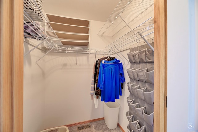 walk in closet featuring visible vents and carpet