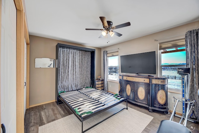 bedroom with ceiling fan, baseboards, and wood finished floors