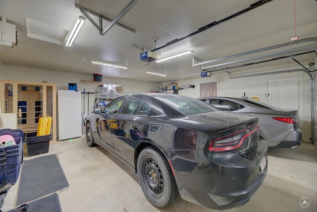 garage with freestanding refrigerator and a garage door opener
