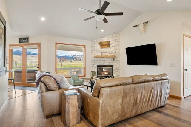 5632 Fairview Ln, Florence, MT 59833 - living area featuring lofted ceiling, baseboards, ceiling fan, a fireplace, and wood finished floors