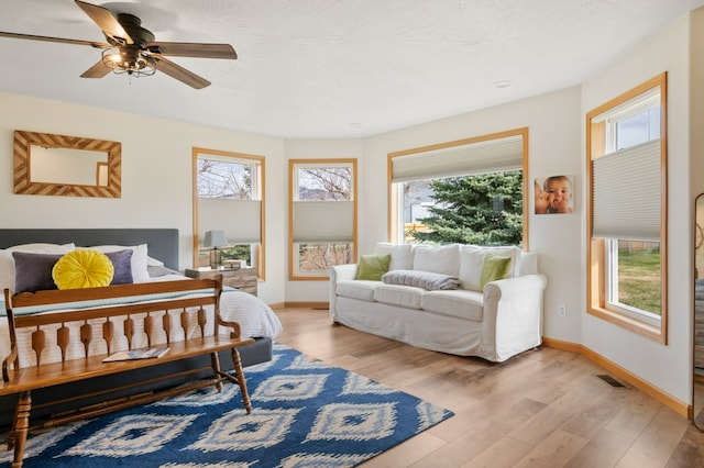 5632 Fairview Ln, Florence, MT 59833 - bedroom with baseboards, a textured ceiling, a ceiling fan, and light wood-type flooring