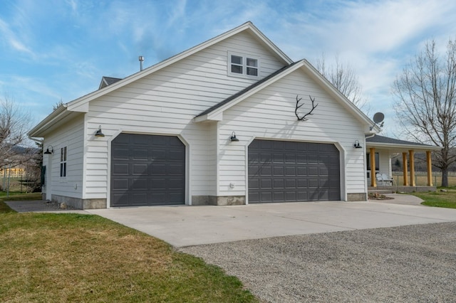 5632 Fairview Ln, Florence, MT 59833 - view of side of property with covered porch, concrete driveway, a garage, and a yard
