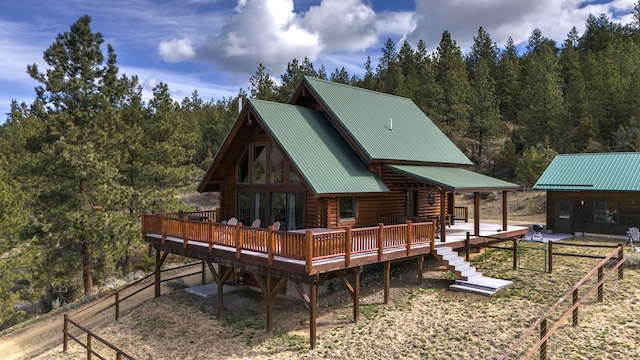 3340 Rome Ln, Stevensville, MT 59870 - back of property featuring log exterior, a wooden deck, metal roof, and a forest view